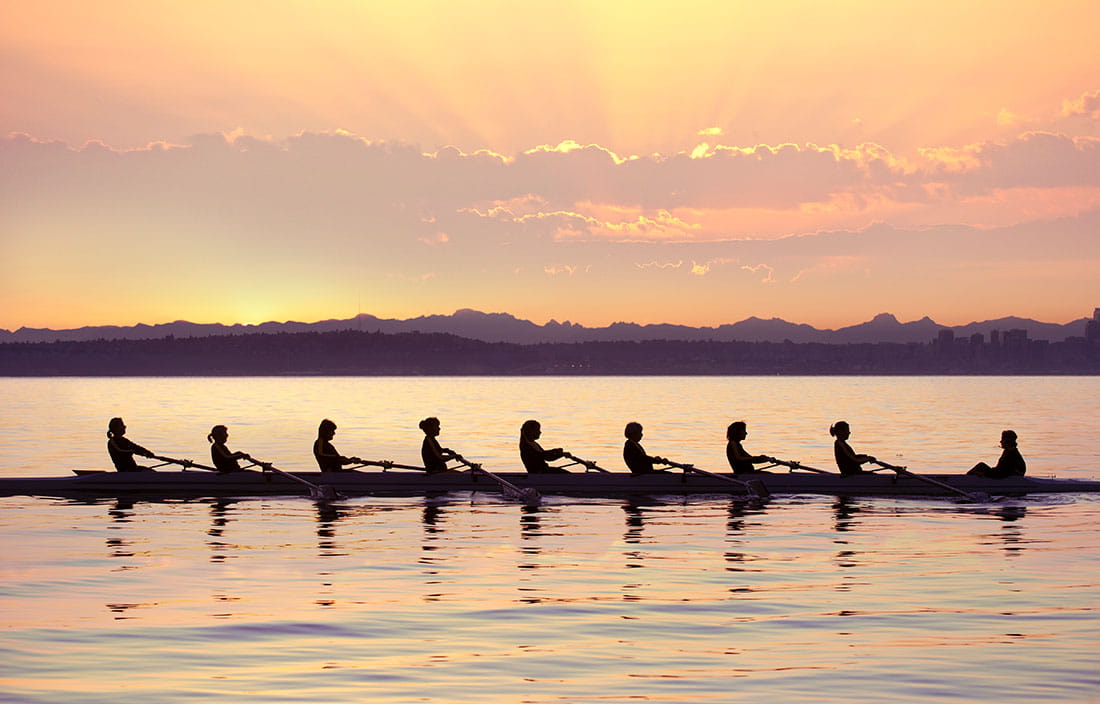 A kayak team rowing through the water.