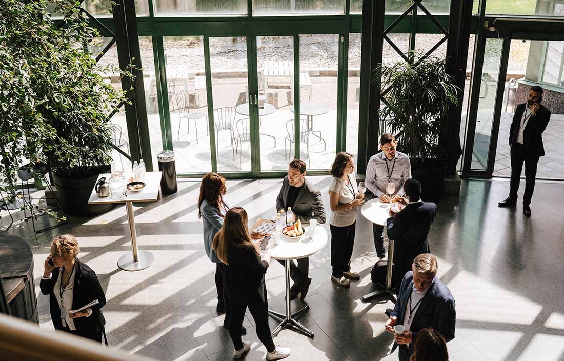 Conference attendees having drinks and talking at a cocktail event.