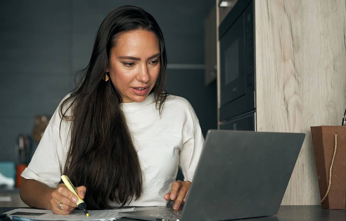Person taking notes from laptop computer.