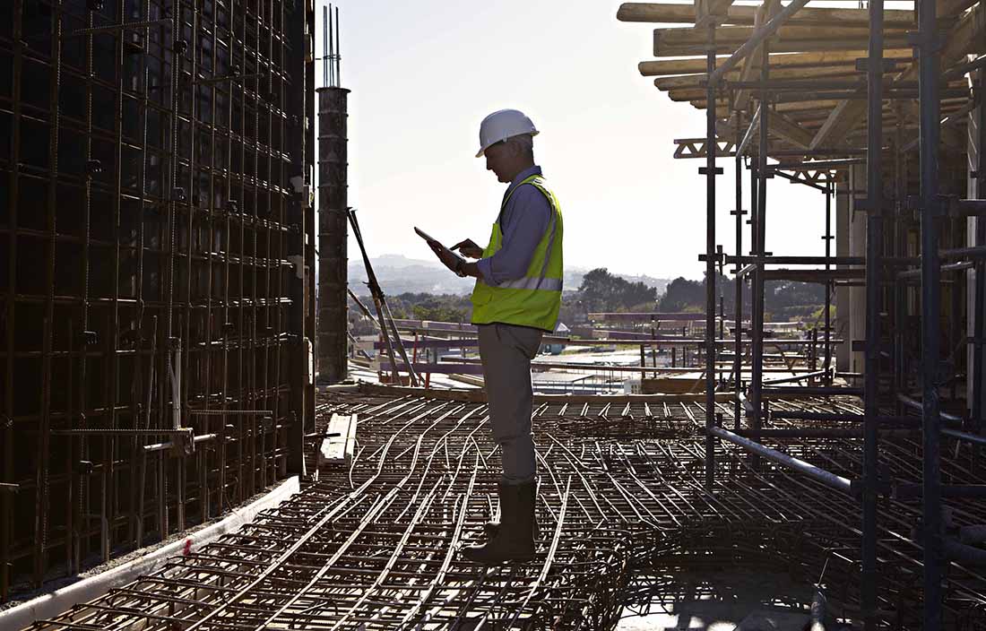 Worker standing on metal beams.