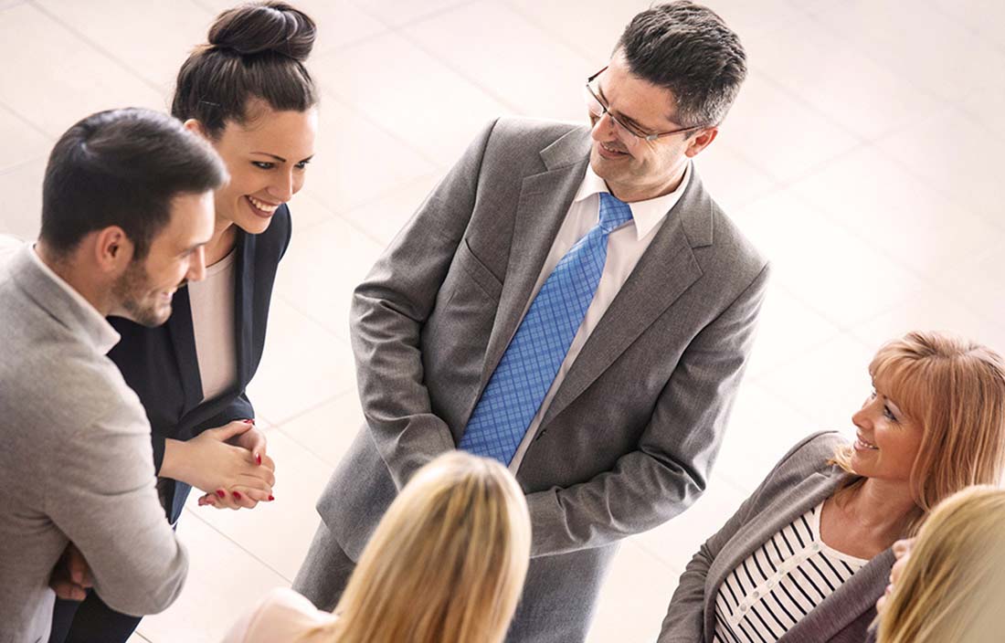 Business professionals standing talking at a conference.