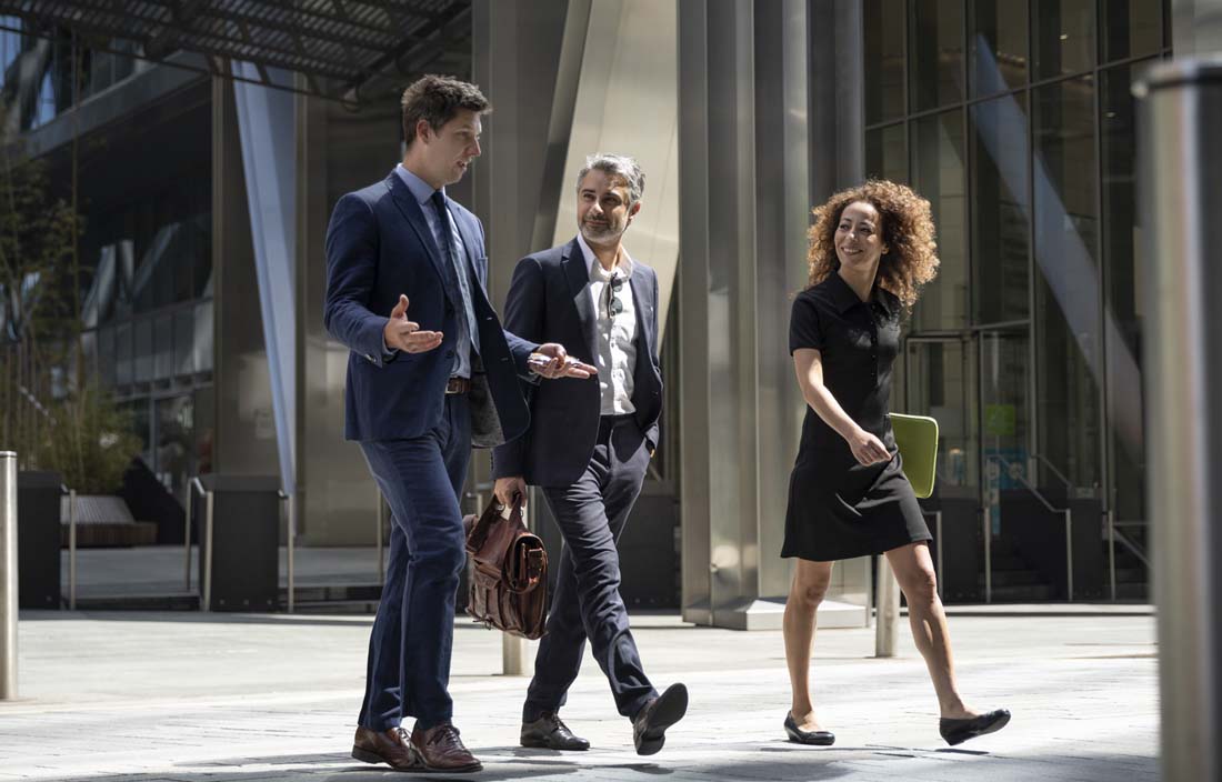 Business professionals walking down a street together discussing data governance.