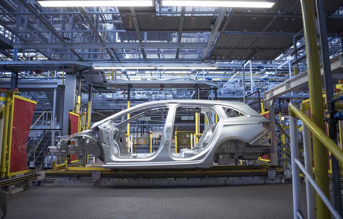Automotive vehicle being assembled in factory.