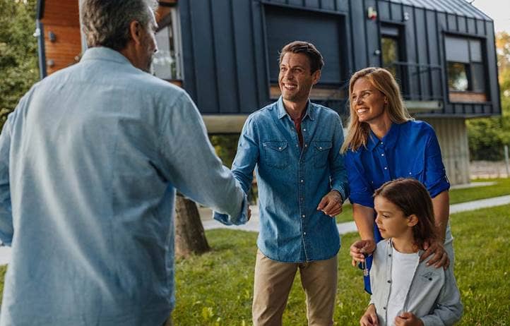 Wealthy family shaking hands with a financial advisor and discussing their financial legacy.