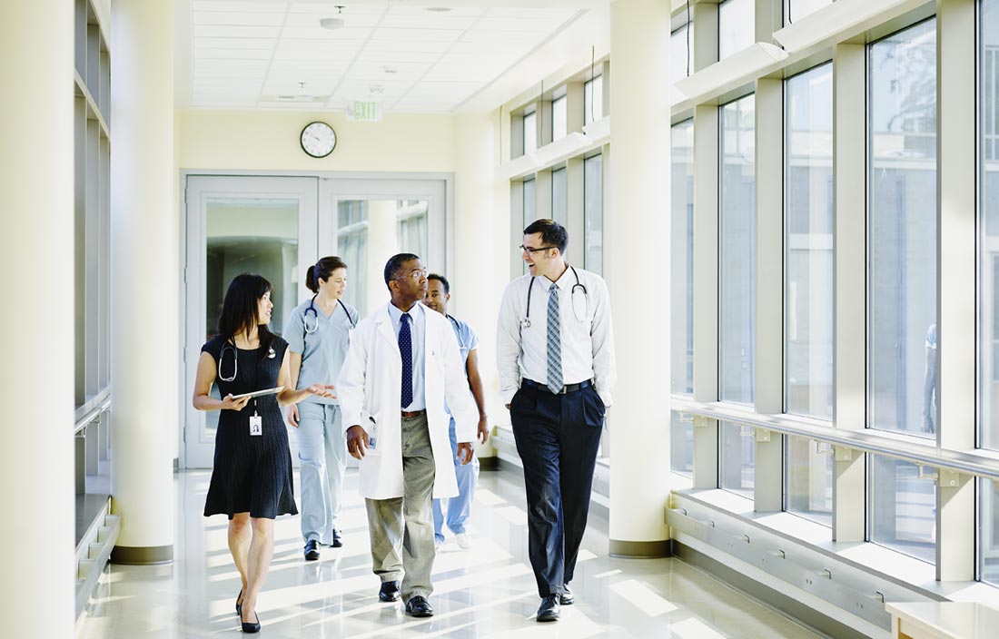 Healthcare professionals walking down a hospital hallway.