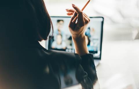 Business professional watching a webinar on their laptop.