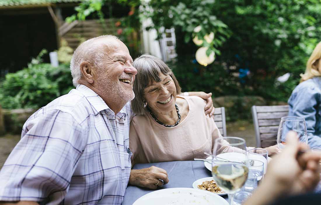 Senior couple hugging in a garden.