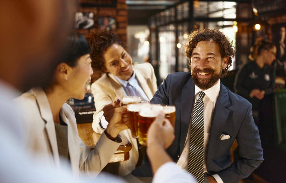 Business professionals smiling and raising their glasses.