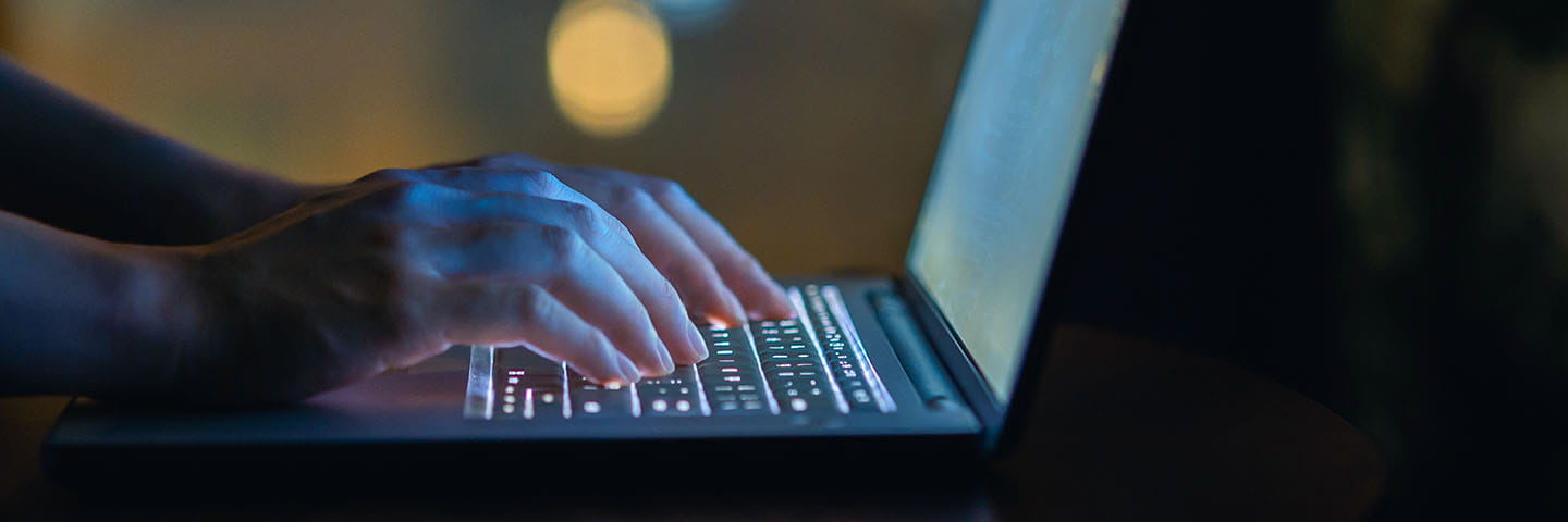 Hands typing on laptop computer.