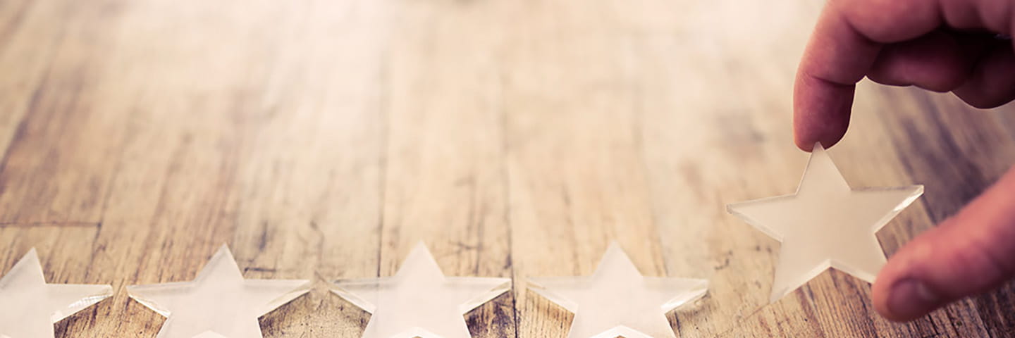 Close-up view of a persons hands laying out decorative stars on a table.
