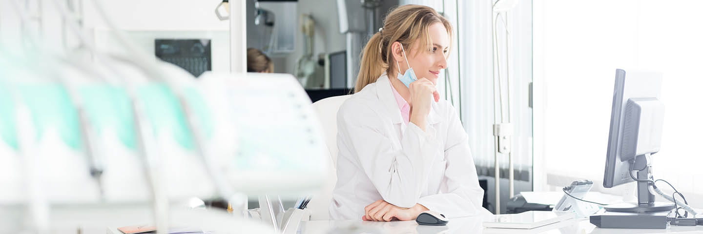 Doctor sitting at a desk using a computer