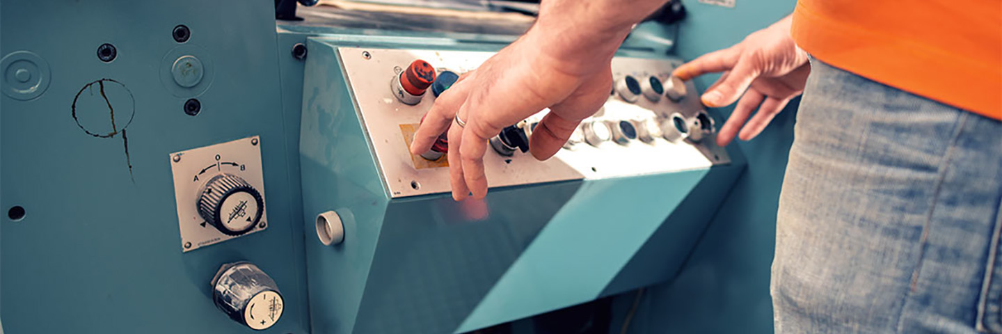 Close-up view of hands operating a machine. 