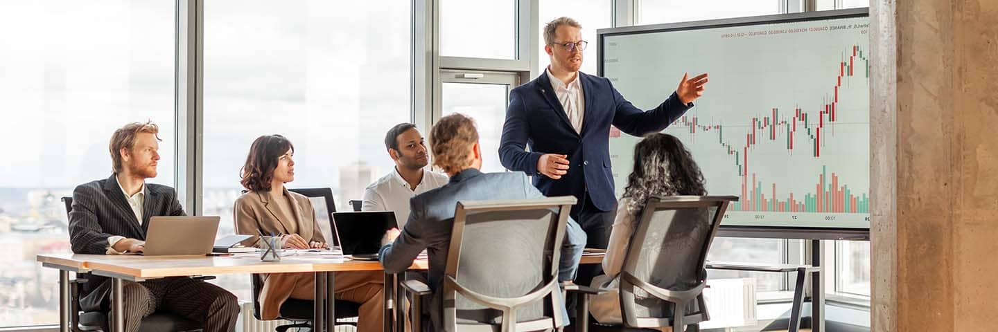Economists referring to a presentation with charts and graphs.