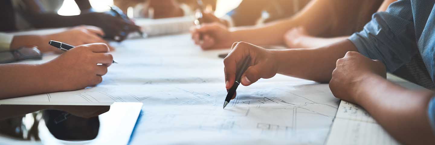 Financial advisors writing notes in a meeting.