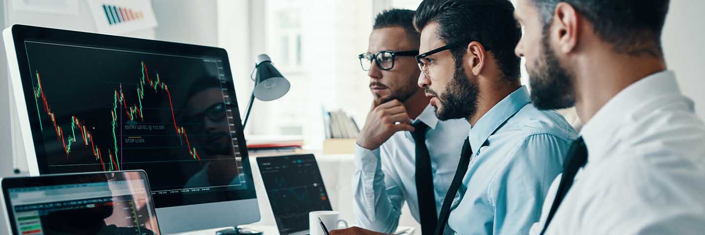 Financial advisors looking at a stock graph on their computer.