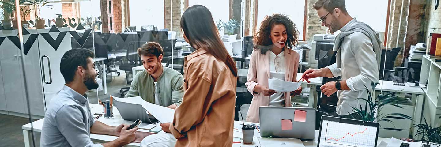 Group of coworkers working and talking in an office.
