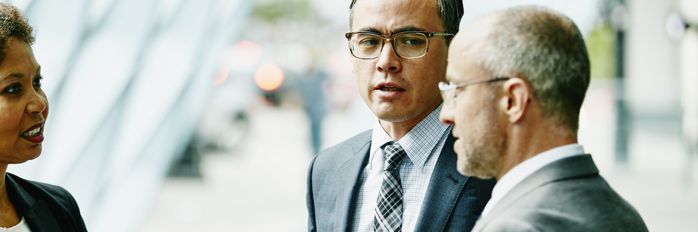 Three business professionals discussing portfolio company operations.