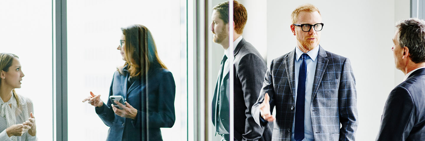 Group of business professionals in suits having a conversation.