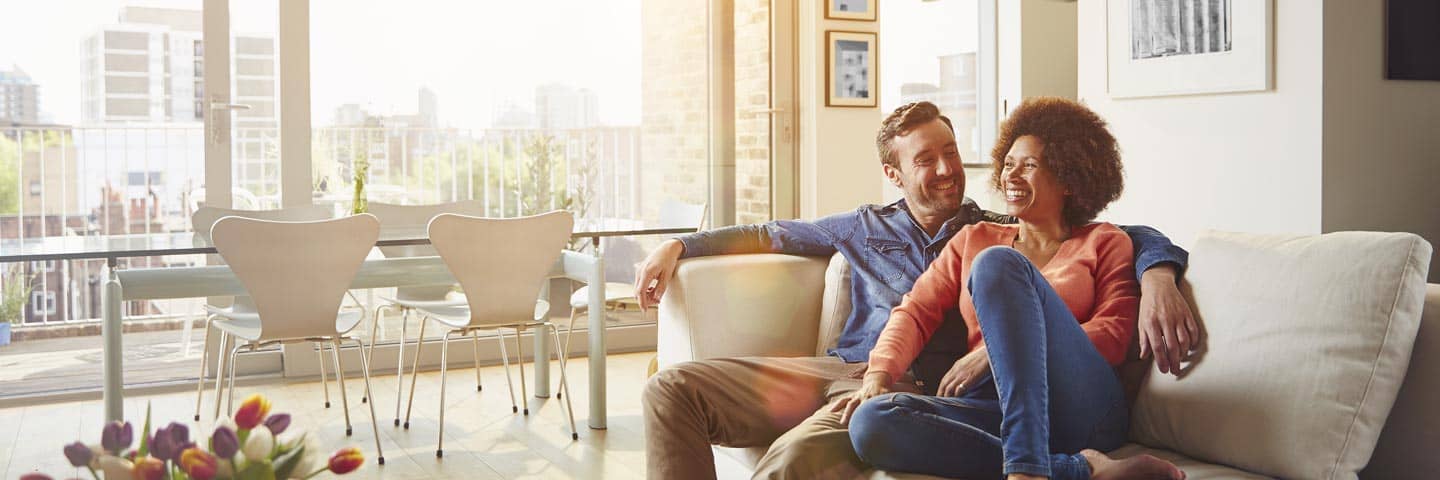 Wealthy couple talking on their couch.