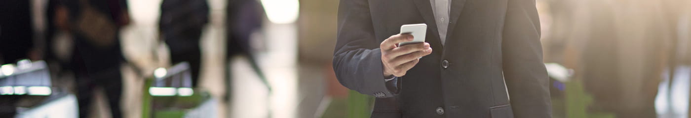 駅で携帯電話を持っている日本のビジネスプロフェッショナルのクローズアップ