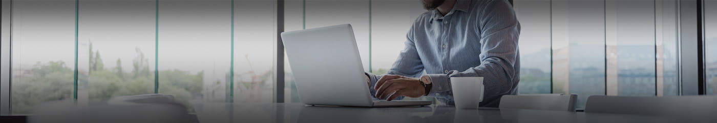 Business professional using a laptop computer to check Plante Moran Webinar FAQs.