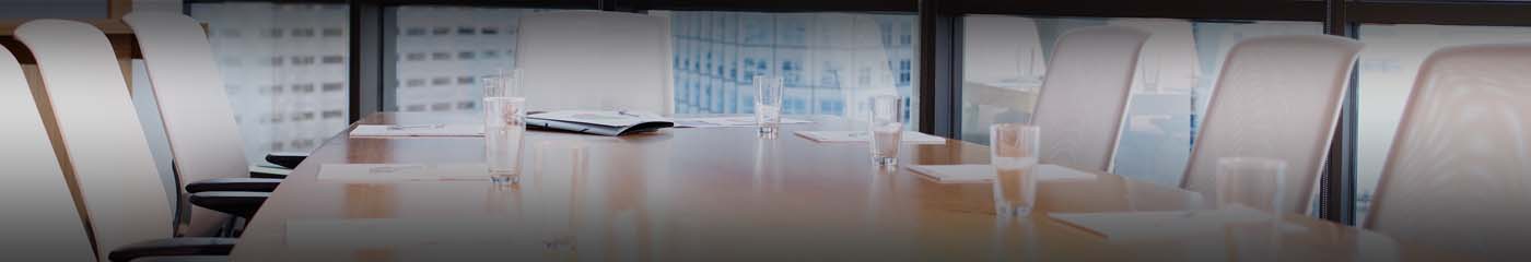 Close-up view of a conference room table with glasses of water on the table.