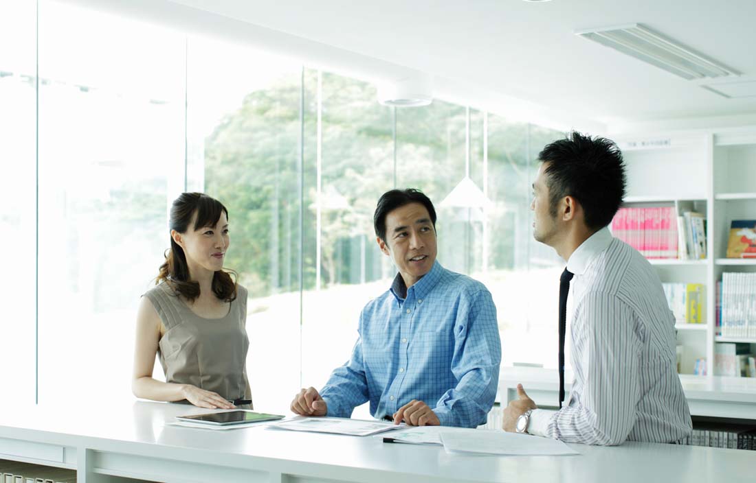 Japanese business professionals smiling at one another.