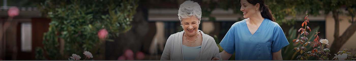Nurse walking with an elderly senior citizen in a nursing home.