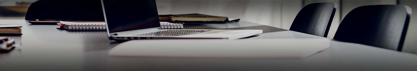 Close-up view of a laptop computer on a conference room table.
