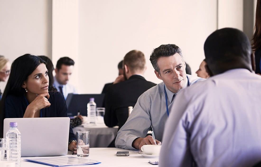 Business people sitting at a table talking.