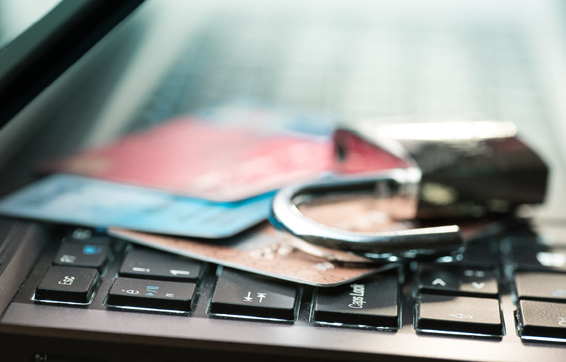 Padlock and credit cards on top of laptop keyboard.