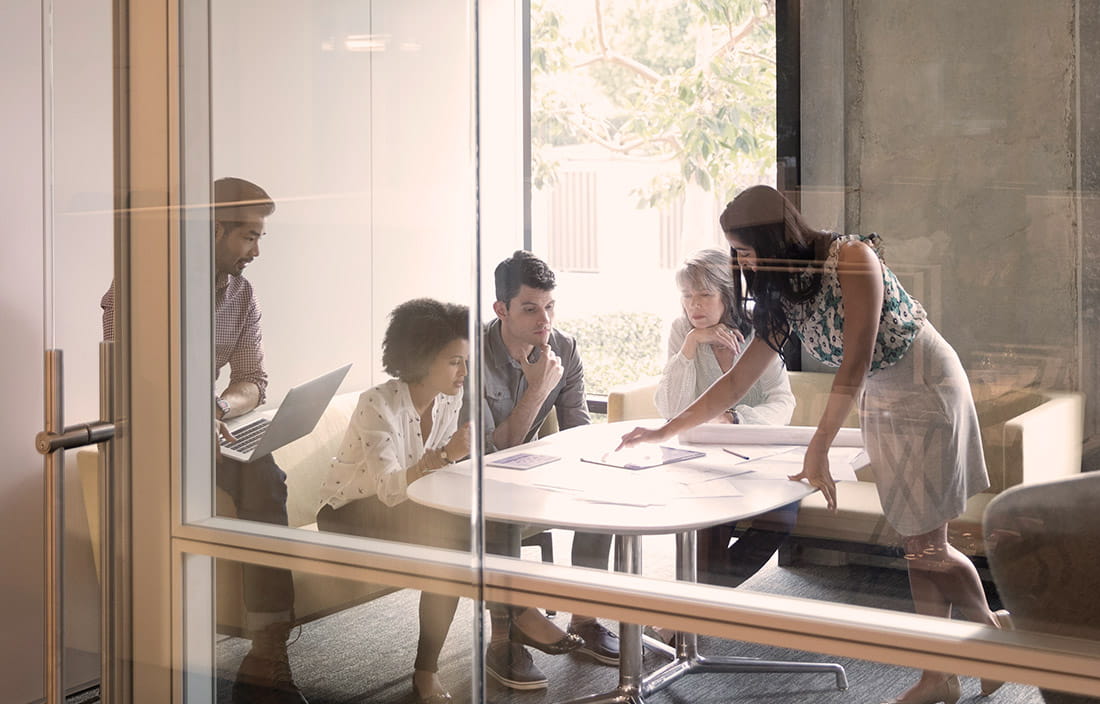 Business people discussing over a document around a table. 