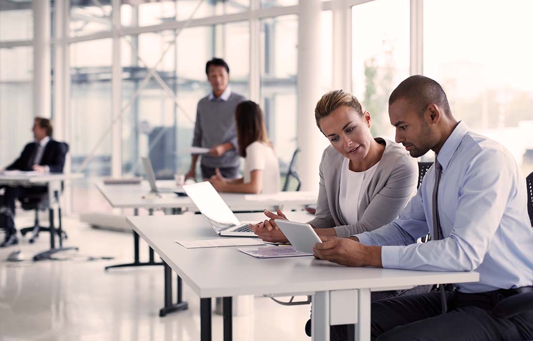 Photo of two businesspeople looking at paperwork in an office.