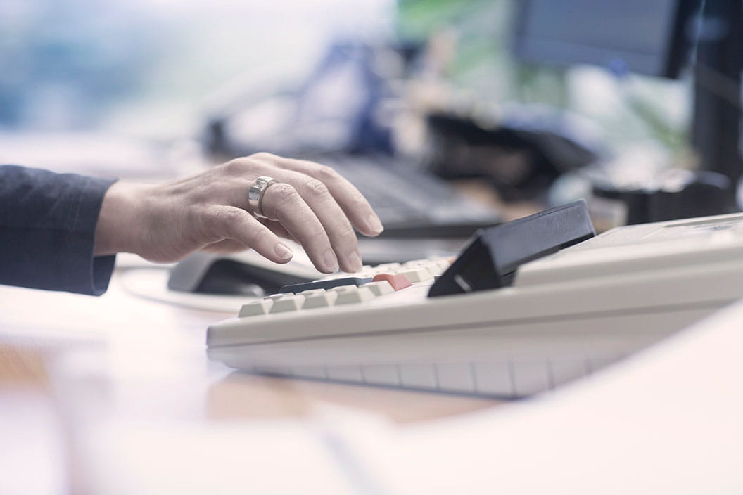 Close up image of woman's hand and calculator.