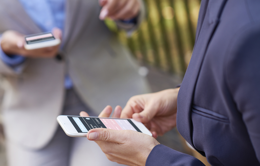 Business people using their cell phones to access Bitcoin trading.