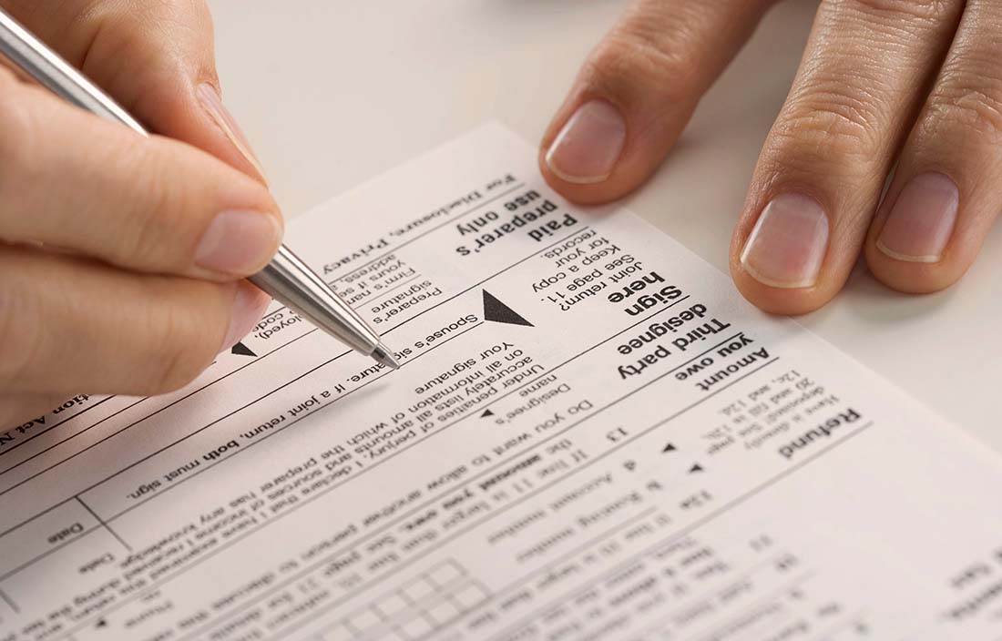 Close up of a tax document being filled out by a person. 
