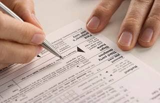 Close up of a tax document being filled out by a person.