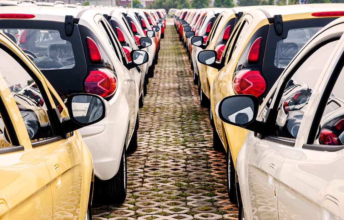 Row of cars lined up in a parking lot. 