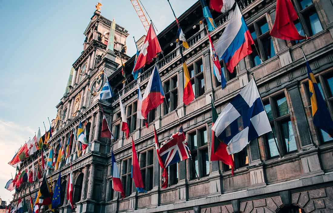 Image of city hall in Antwerp, with flags from many countries.