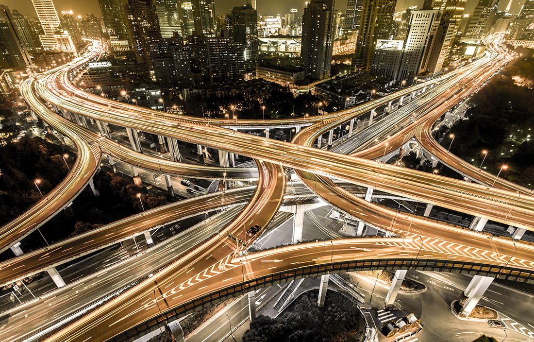 Picture of a busy highway intersection at night. 