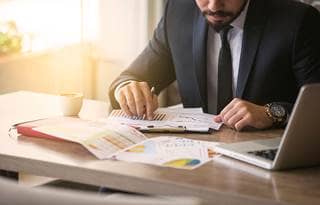 Image of businessman reviewing documets at his desk.