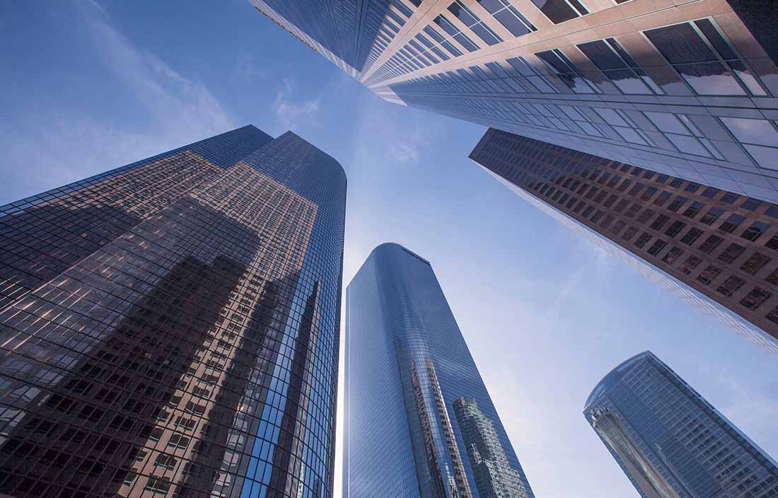 Image of skyscrapers from the ground perspective looking up.