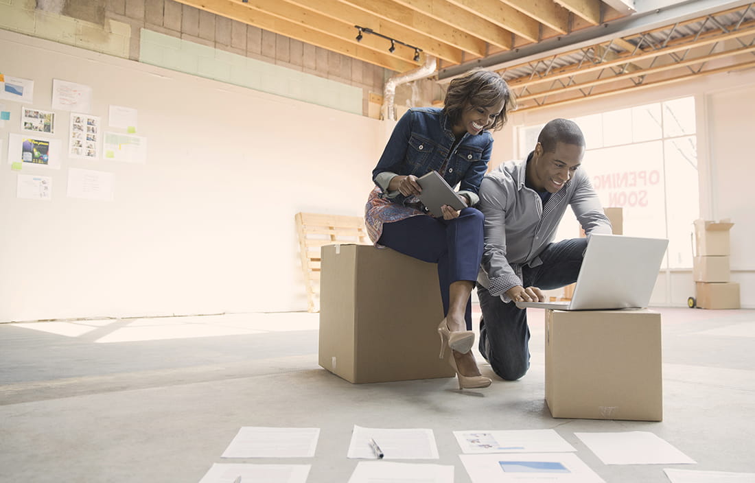 Small business owners discussing employee compensation at a laptop