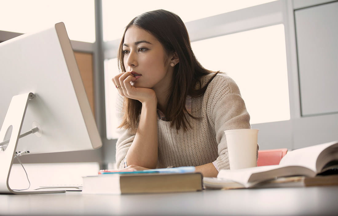 Woman reads cyber best practices on monitor
