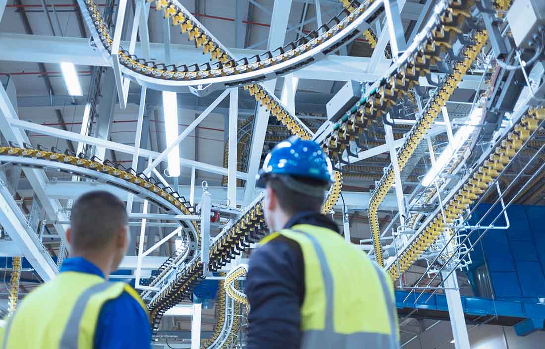 Workers looking at a manufacturing conveyor belt.