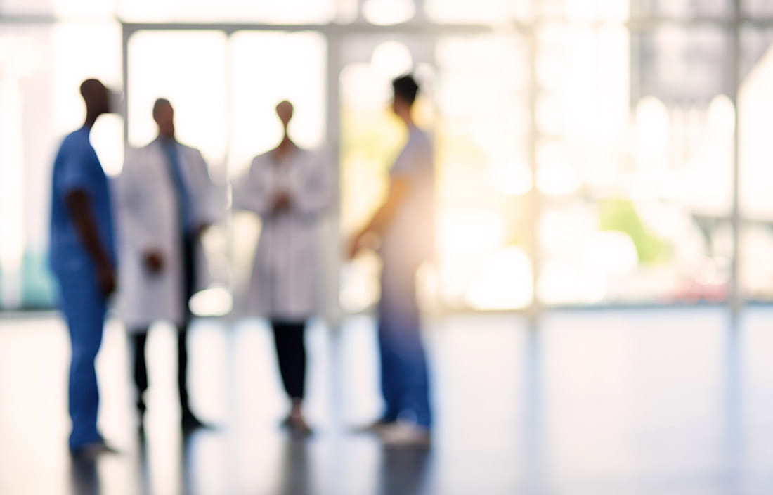 A picture of lab technicians talking in a lobby. 