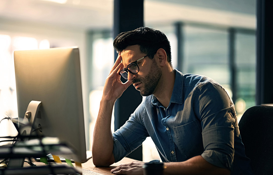 Image of frustrated man in front of computer