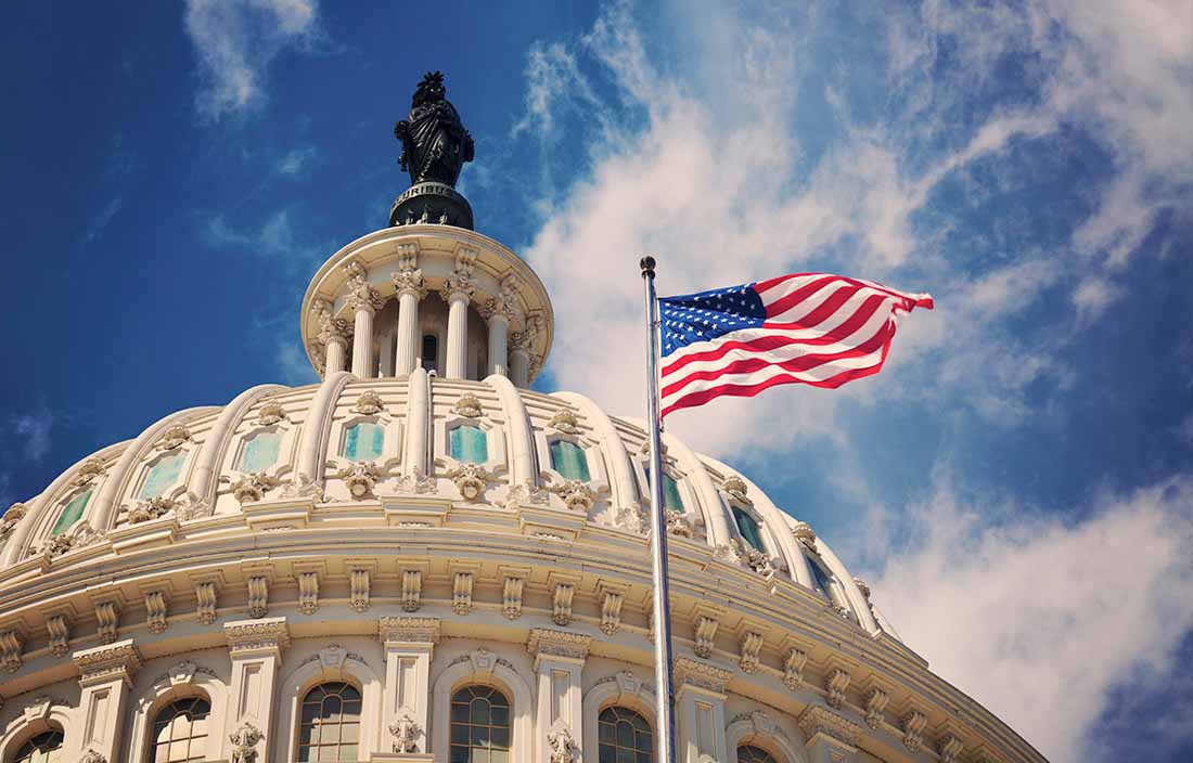 Photo of a United States government building with a flag in front of it. 