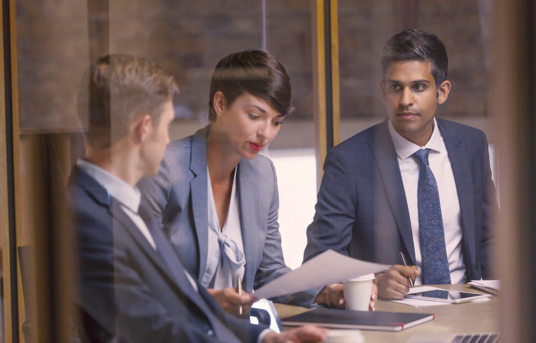 Image of business people having conversation over piece of paper