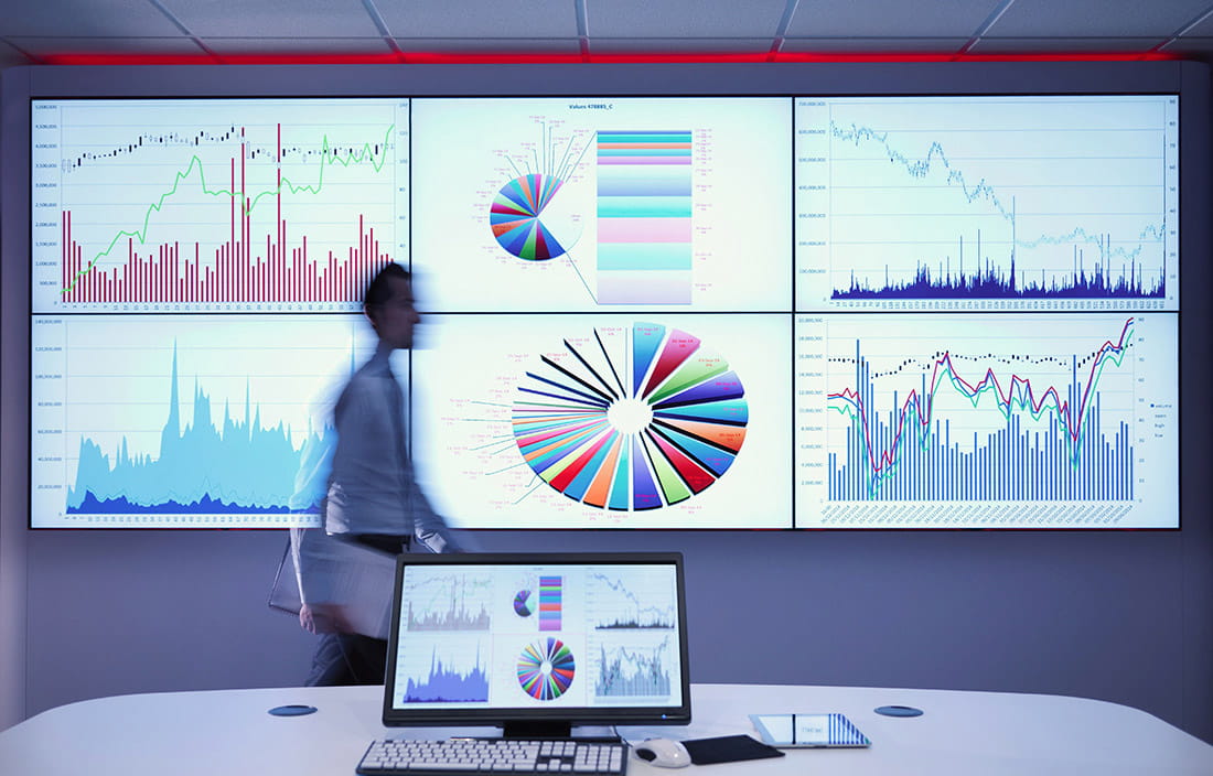 Man walking in front of monitors